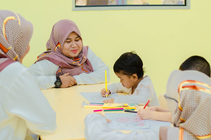 KinderHive teacher supervising preschool children drawing and colouring in class