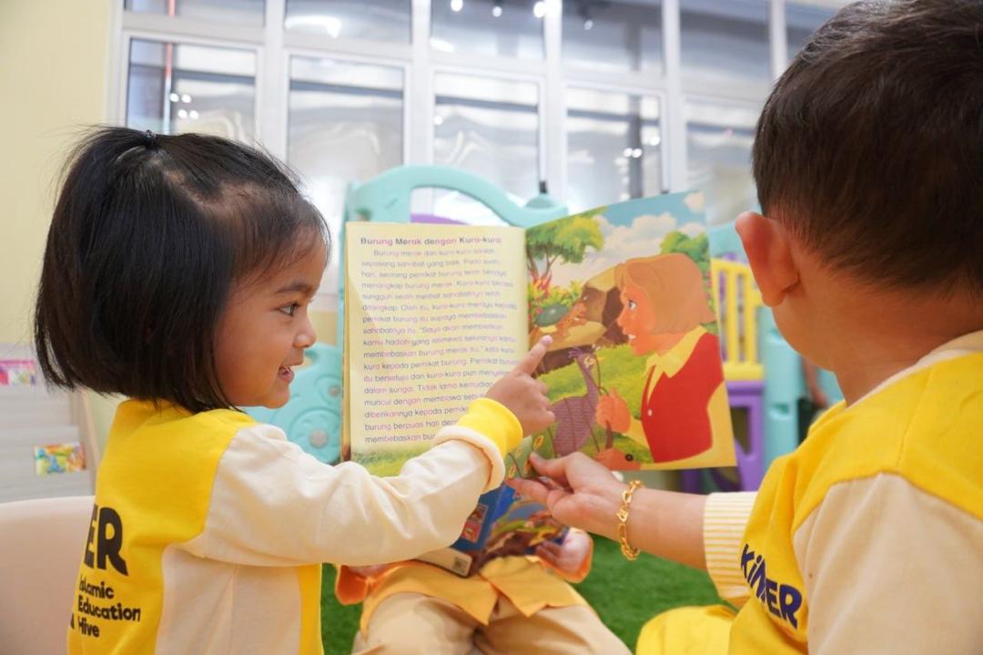 KinderHive preschool children reading a storybook together in the classroom