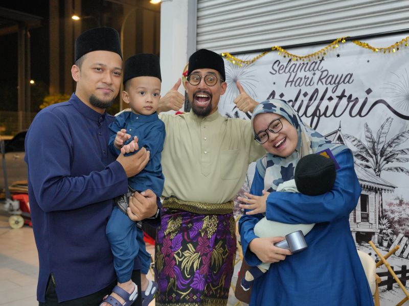 Ustaz Don Daniyal posing with a family during the Meet and Greet Aidilfitri celebration in Cybersouth