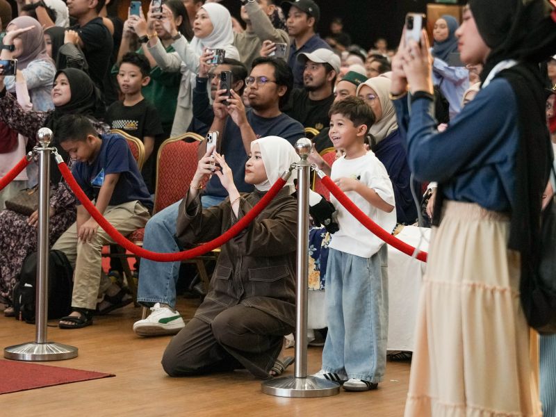 Parents and family members watching and photographing the 2026 Junior Concert