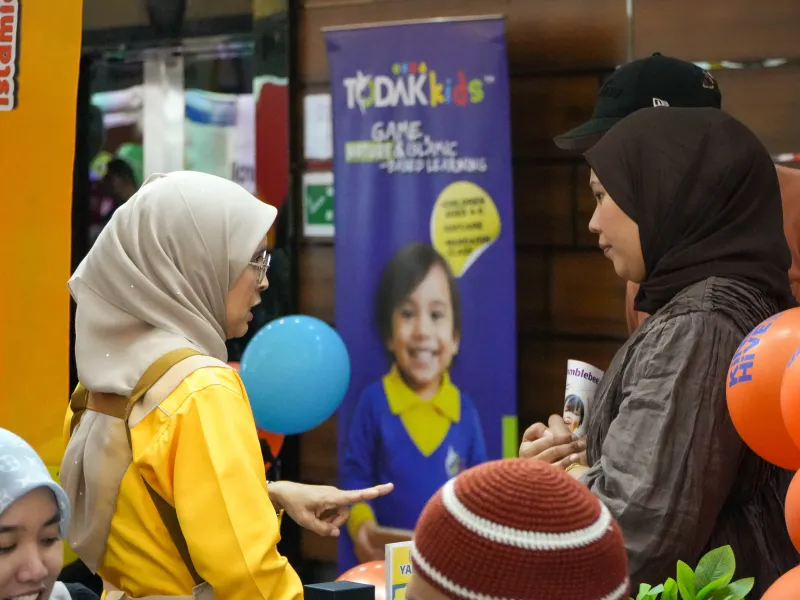 Visitors discussing KinderHive programmes at the ECEE 2026 booth