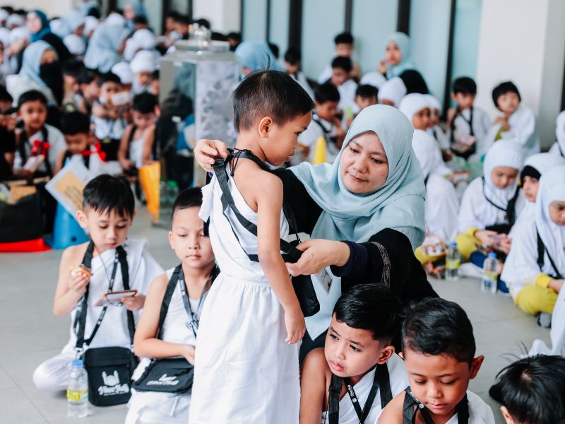 Teacher supporting a child during the KinderHive HiveHajj learning programme