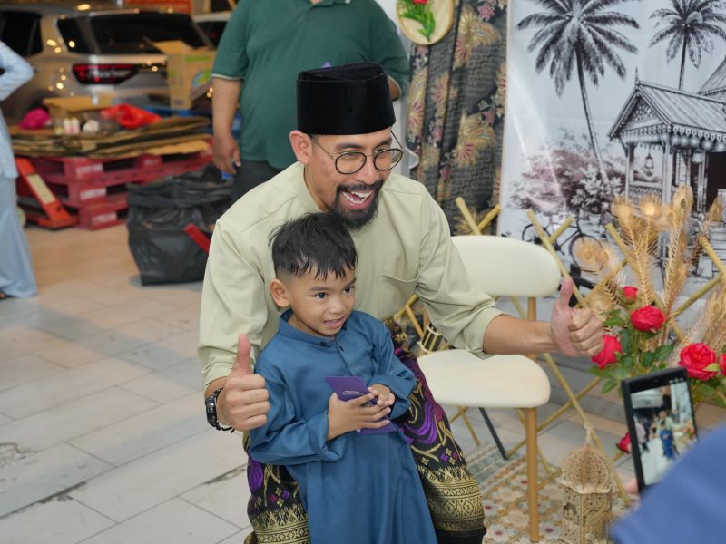 Ustaz Don Daniyal greeting a child during the KinderHive Meet and Greet in Cybersouth