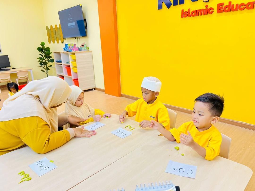 KinderHive teacher guiding preschool children with hands-on learning activity in class