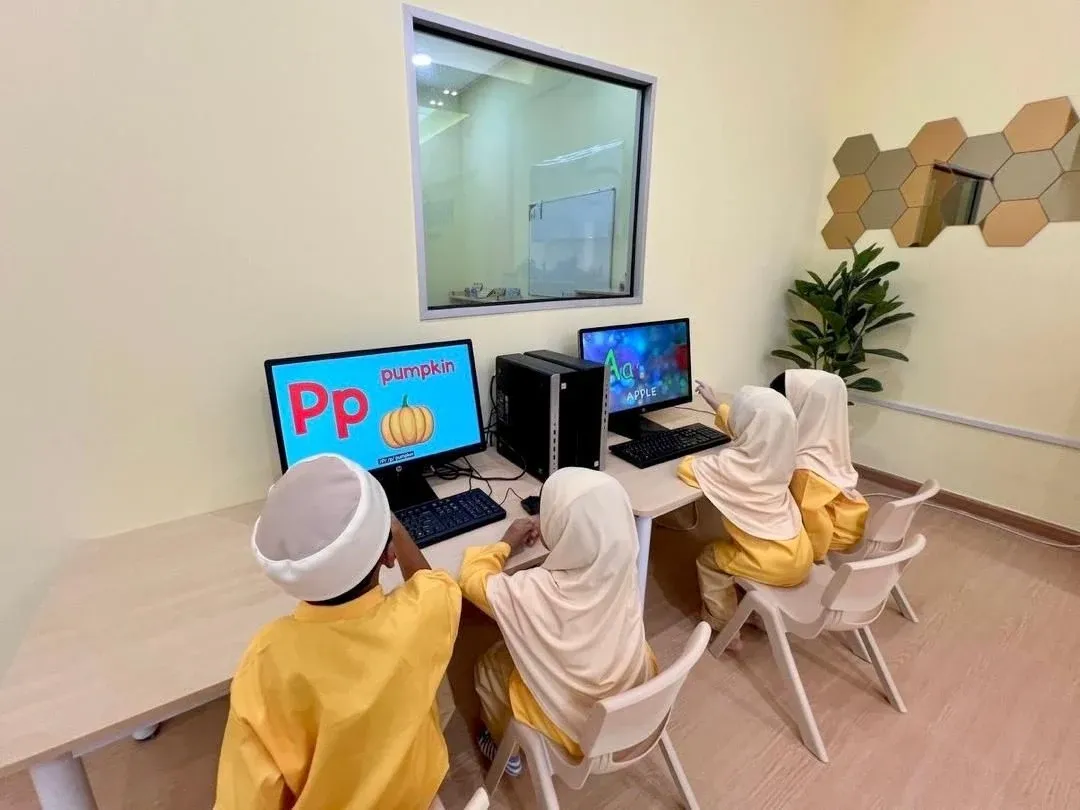 KinderHive preschool children learning English on computers in class
